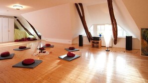 A spacious room with wooden flooring, yoga mats, and a large window. - Semi-detached house FeWo 1 - holiday homes Ohlenbusch (Worpswede)