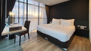 A modern hotel room with a large bed, a desk, and a chair. - Good Dream Premier (Hat Yai)