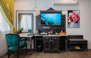 A modern living room with a TV, a dining table, a sofa, and a coffee table. - Athena Hotel (Quy Nhon Nam)