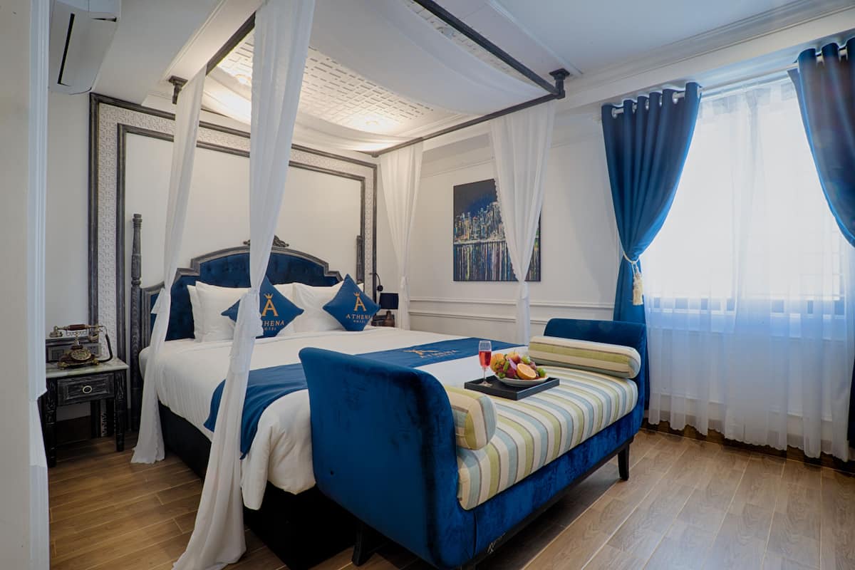 Um quarto com cama de dossel, mesa de cabeceira e janela com cortinas.