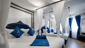 A hotel room with a large bed, a smaller bed, and a sitting area. There are two large windows with curtains, a ceiling with a decorative pattern, and a wall with a framed picture. - Athena Hotel (Quy Nhon Nam)
