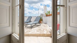 An open door leading to a balcony with two lounge chairs and a potted plant. - Le Cupole -  Mosaico con Terrazza by Wonderful Italy (Ostuni)