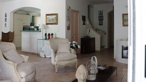 Una sala de estar con un sofá, sillones, una mesa de centro y una escalera que conduce a otra habitación.