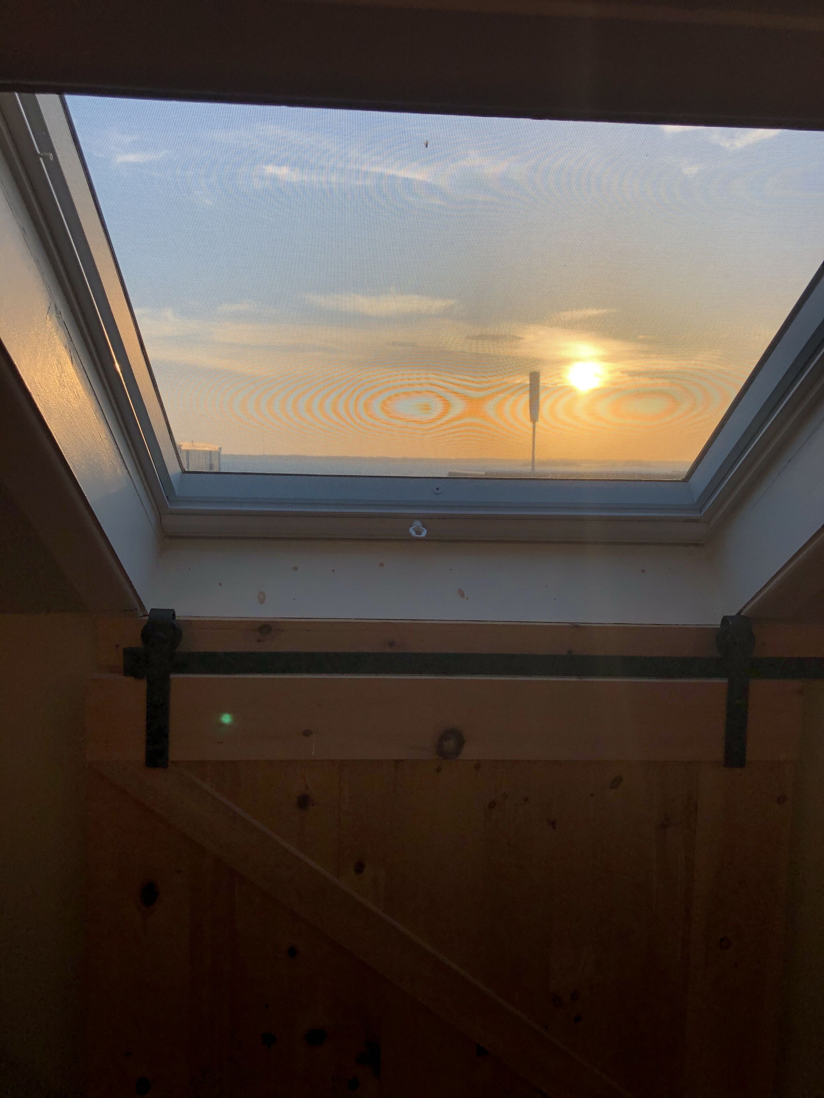 Ein Oberlicht mit Blick auf den Himmel und die Sonne.