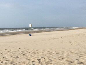 A sandy beach with footprints leading to a lifeguard stand. - Renovated detached luxury bungalow (Sint Maartenszee)