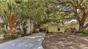 A residential area with a paved driveway leading to a house with a small porch. - Fun Weeki Wachee River Boathouse (Weeki Wachee)