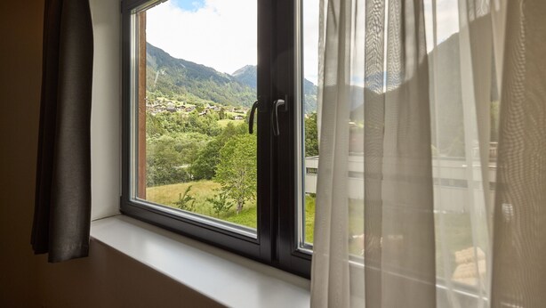 A window with a view of a mountainous landscape and a village below. - 4805 Cirrus 5 (St. Gallenkirch)