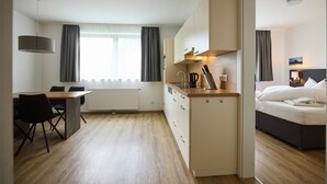 A compact hotel room with a kitchenette, a dining area, and a bed. - 4805 Cirrus 5 (St. Gallenkirch)