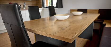 A dining area with a wooden table and black leather chairs.