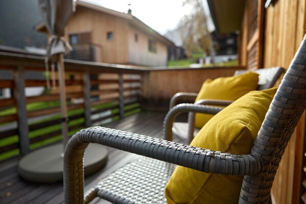 Wicker chairs with yellow cushions on an outdoor deck. - 46142 Montan 14 OG (St. Gallenkirch)