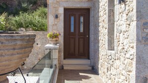 A stone building with a wooden door and a small window. - Villa Kallisto with Infinity Pool & Stunning Sea View in Perigiali, Lefkada!!! (Perigiali)