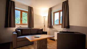 Een moderne woonkamer met een bank, een salontafel en een lamp.