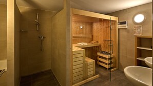 A modern bathroom with a wooden sauna, a shower, and a sink.