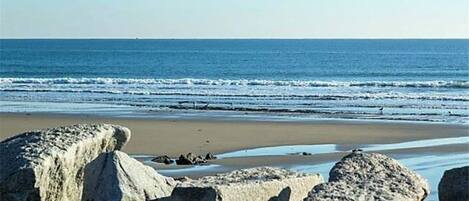 Rannalla, aurinkotuoleja, rantapyyhkeitä