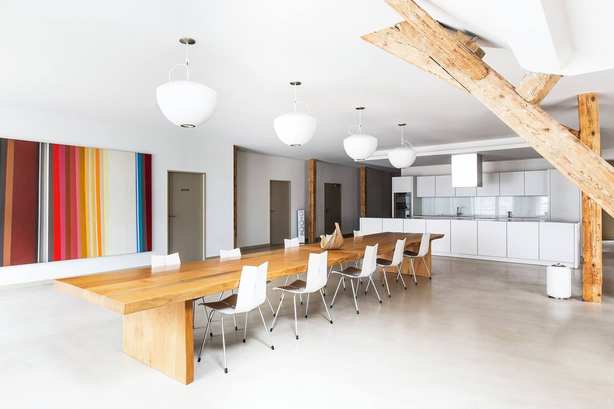 Una cocina moderna con armarios blancos y una escalera de madera.