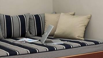 Ein modernes Zimmer mit einer Couch, einem Laptop und einer Wandleuchte.