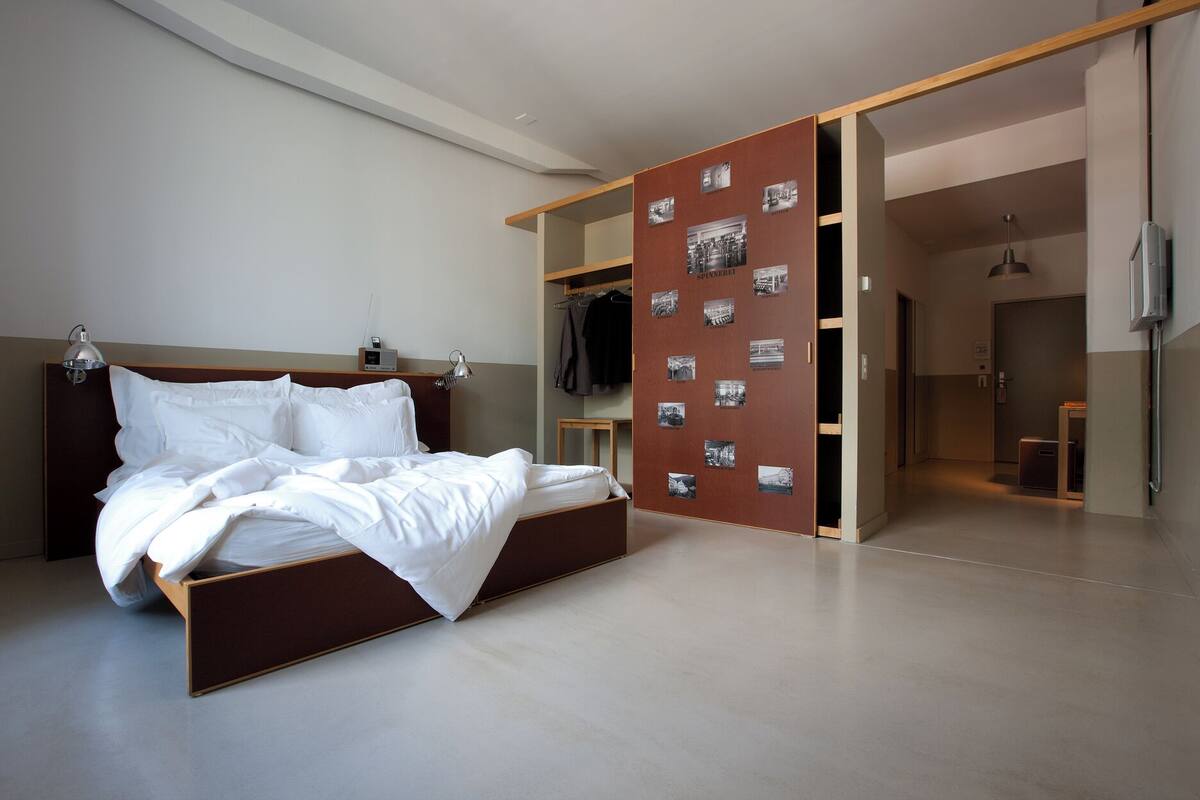 Un dormitorio moderno con una cama grande, un armario con fotografías y un vestidor.