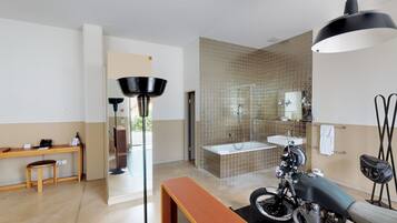 A modern bathroom with a bathtub, a toilet, and a shower area.