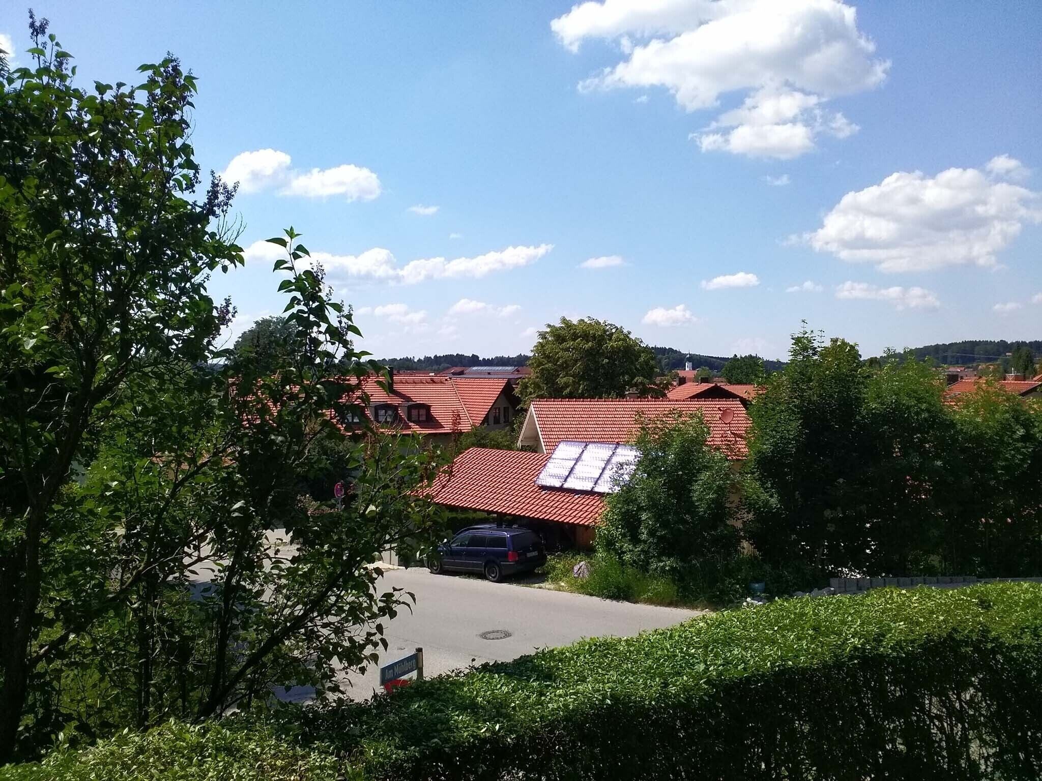 Et boligområde med røde tage, en vej og grønt.