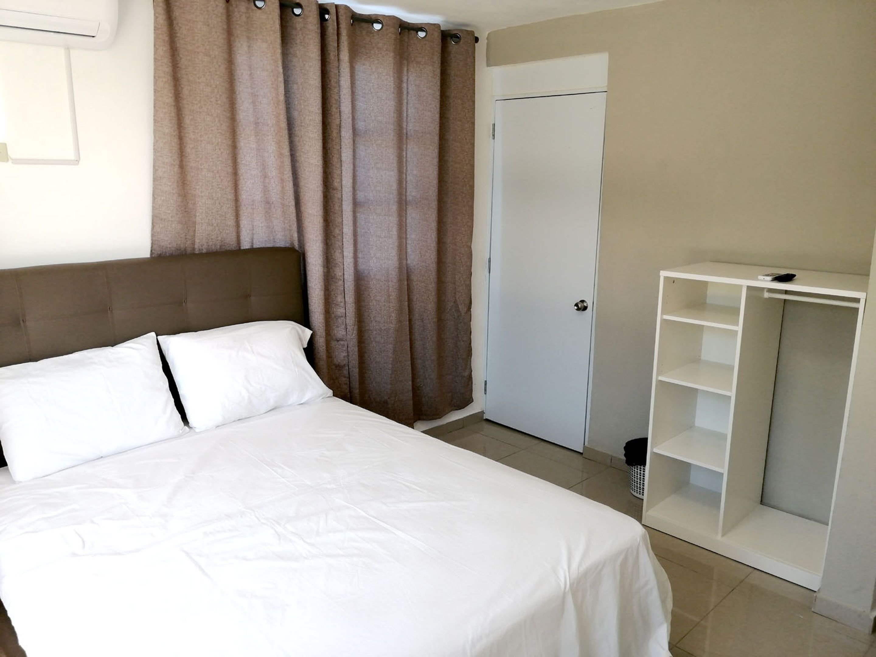 Un dormitorio con cama, armario y puerta.