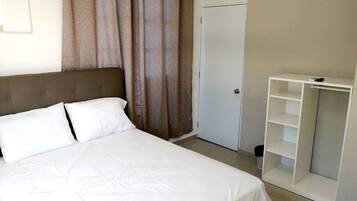 Un dormitorio con cama, armario y puerta.