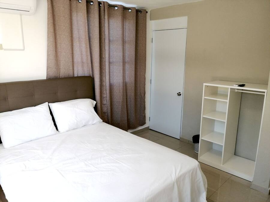 Un dormitorio con cama, armario y puerta.