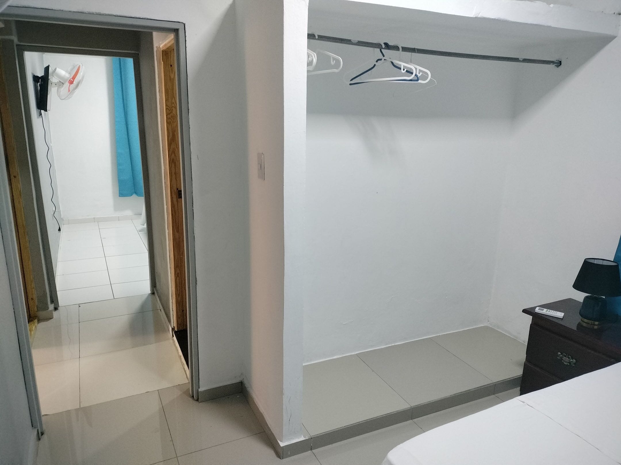 Una habitación con armario, cama, escritorio y silla.