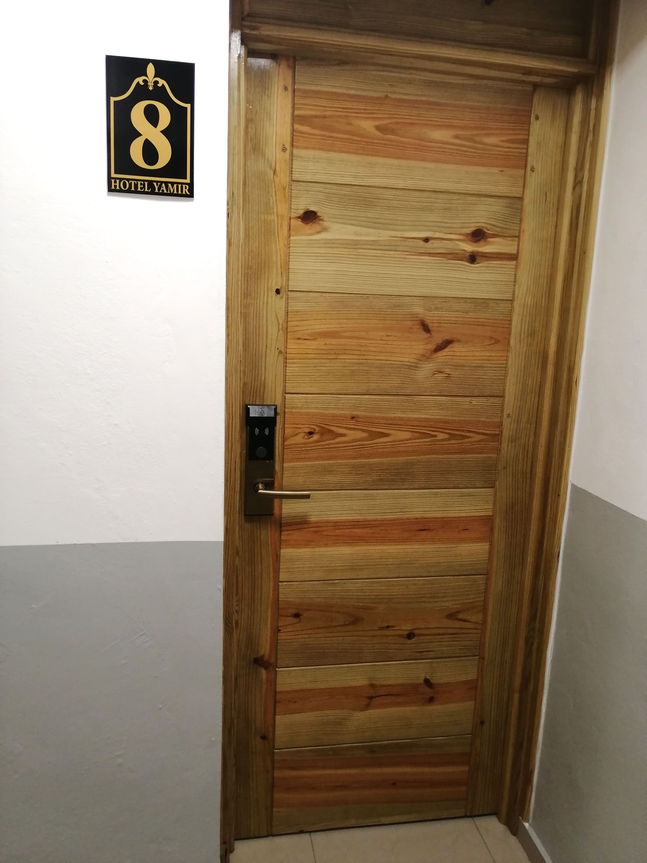 A wooden door with a number 8 sign above it, indicating room number 8.