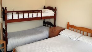 A room with two wooden bunk beds, each with a pillow and a small wooden nightstand. - Glen Villa Flat 3 - 4 Berth (Great Yarmouth)