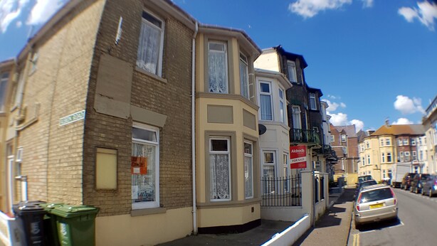 A corner building with a bay window, a 'For Sale' sign, and a parked car on the street. - Glen Villa Flat 3 - 4 Berth (Great Yarmouth)