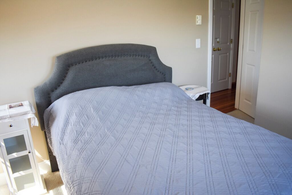 Une chambre à coucher avec un lit, une table de chevet et une porte.