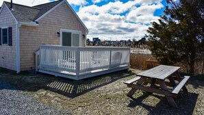A single-story house with a white porch and a picnic table.