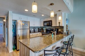 Enjoy cooking in this well-equipped kitchen with a central island, oven, and stainless steel appliances.