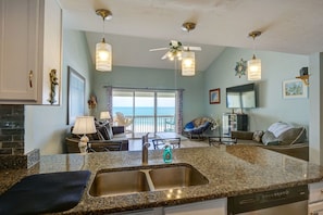 Enjoy ocean views from the spacious living area, featuring a comfortable seating arrangement and large windows.