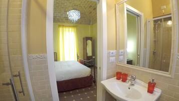 Une salle de bain d’hôtel avec un lit, un lavabo et une douche.