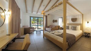 Una cama con dosel, un escritorio de madera, un sofá y una mesita de noche en una habitación luminosa con ventanas amplias.