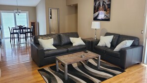 Una sala de estar moderna con un sofá modular, una mesa de centro y un comedor con mesa y sillas.
