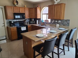 Enjoy cooking and dining in this well-equipped kitchen with a central island, sink, and ample counter space.