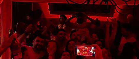 Un espacio interior lleno de gente levantando sus teléfonos, probablemente en un concierto o evento.