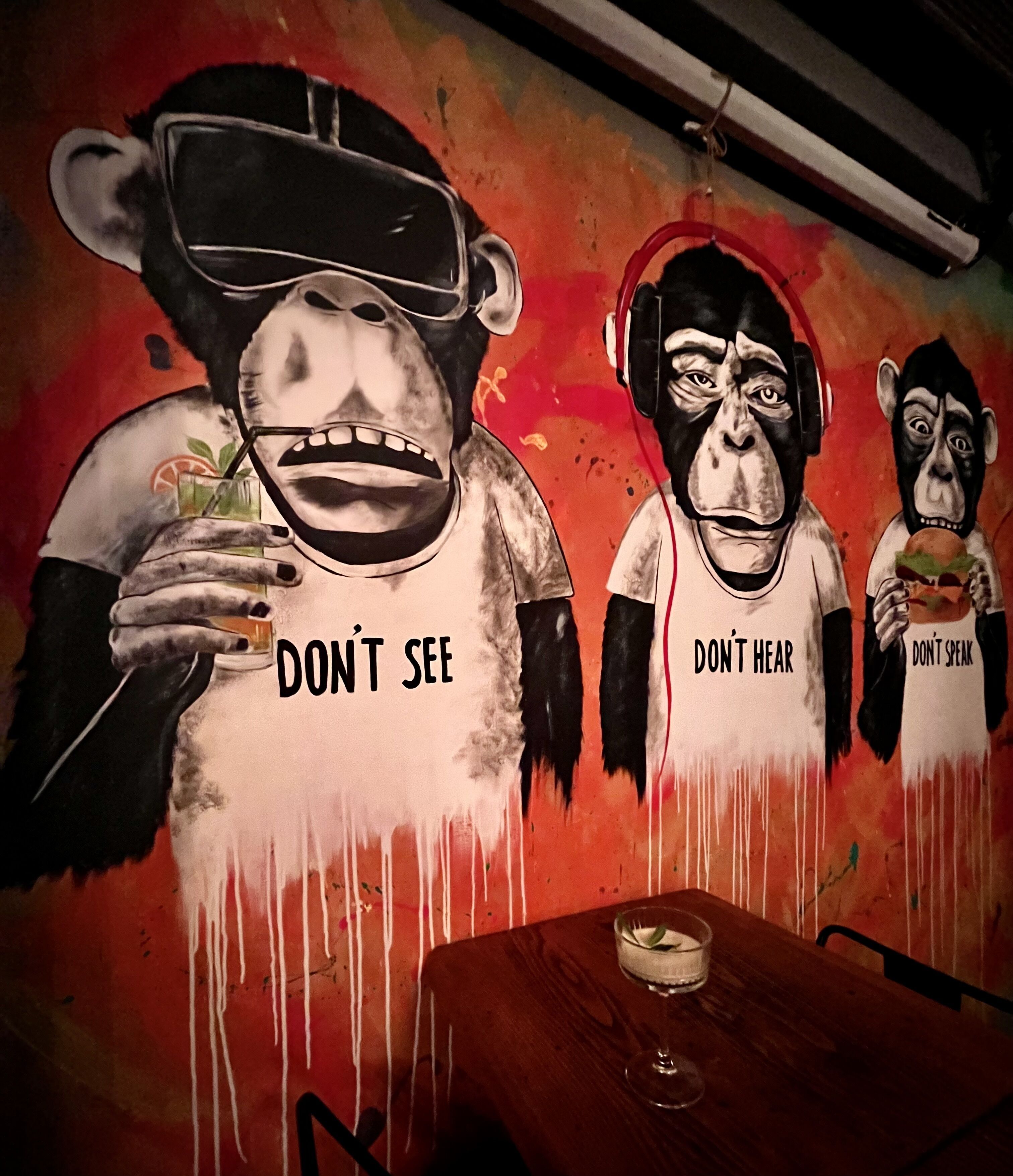 Une fresque représentant trois personnages, chacun portant une phrase différente sur son vêtement : « NE REGARDE PAS », « N’ÉCOUTE PAS » et « NE PARLE PAS ».