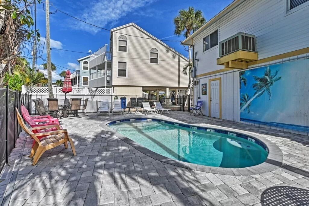 A swimming pool with lounge chairs and a patio area.