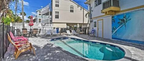 A swimming pool with lounge chairs and a patio area.
