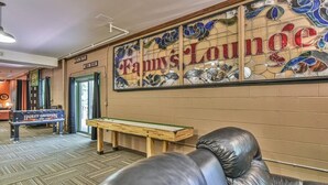 Un hall d’entrée avec un banc Harley-Davidson, une table en bois et un mur orné d’une enseigne indiquant « Fanny’s Lounge ».