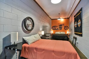 A hotel room with a large bed, a smaller bed, a wall-mounted tire, and a motorcycle mural. - East AVL, 7 miles to Downtown, Game Room, Hot Tub (Asheville)
