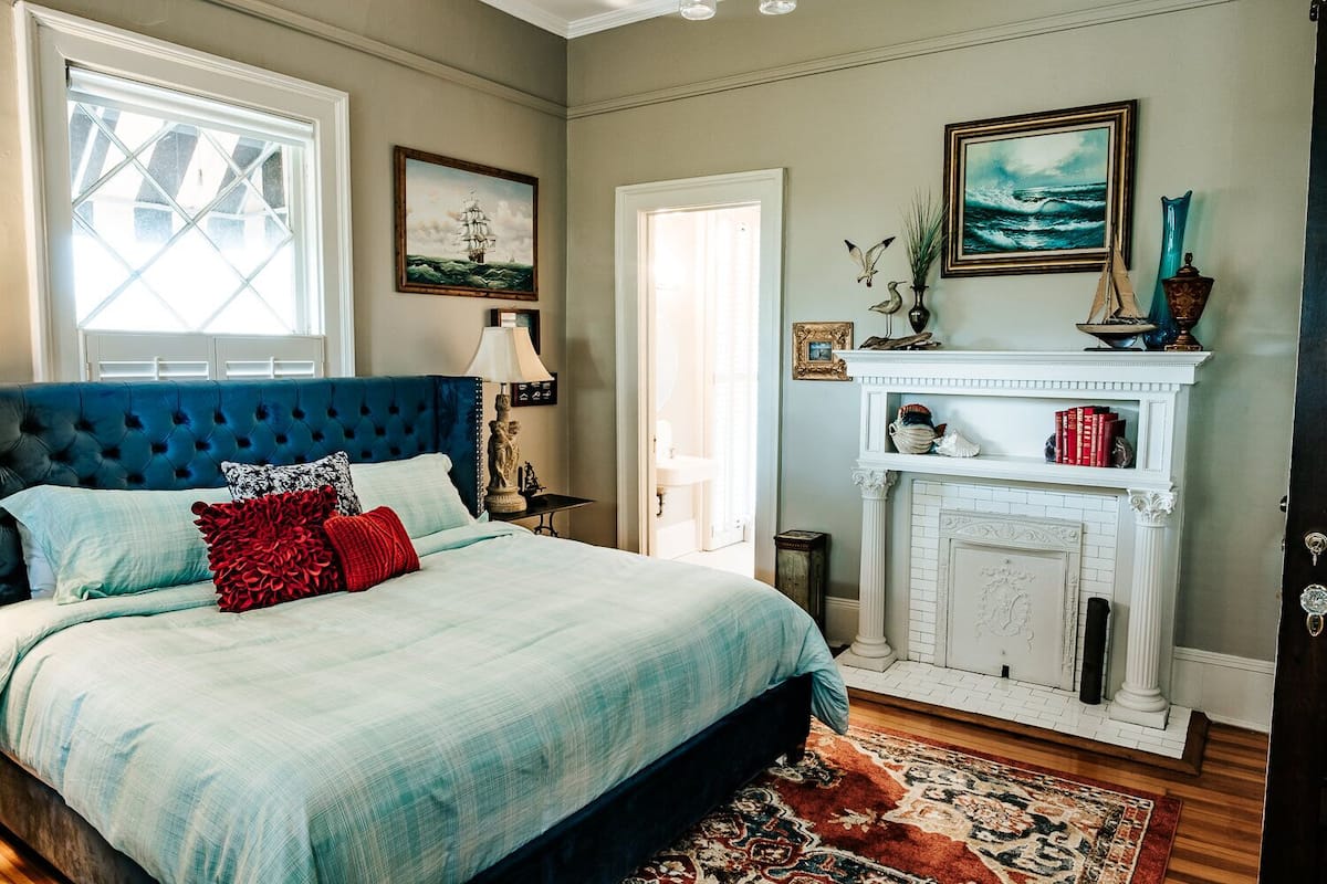 A bedroom with a large bed, a fireplace, and nautical-themed decor.