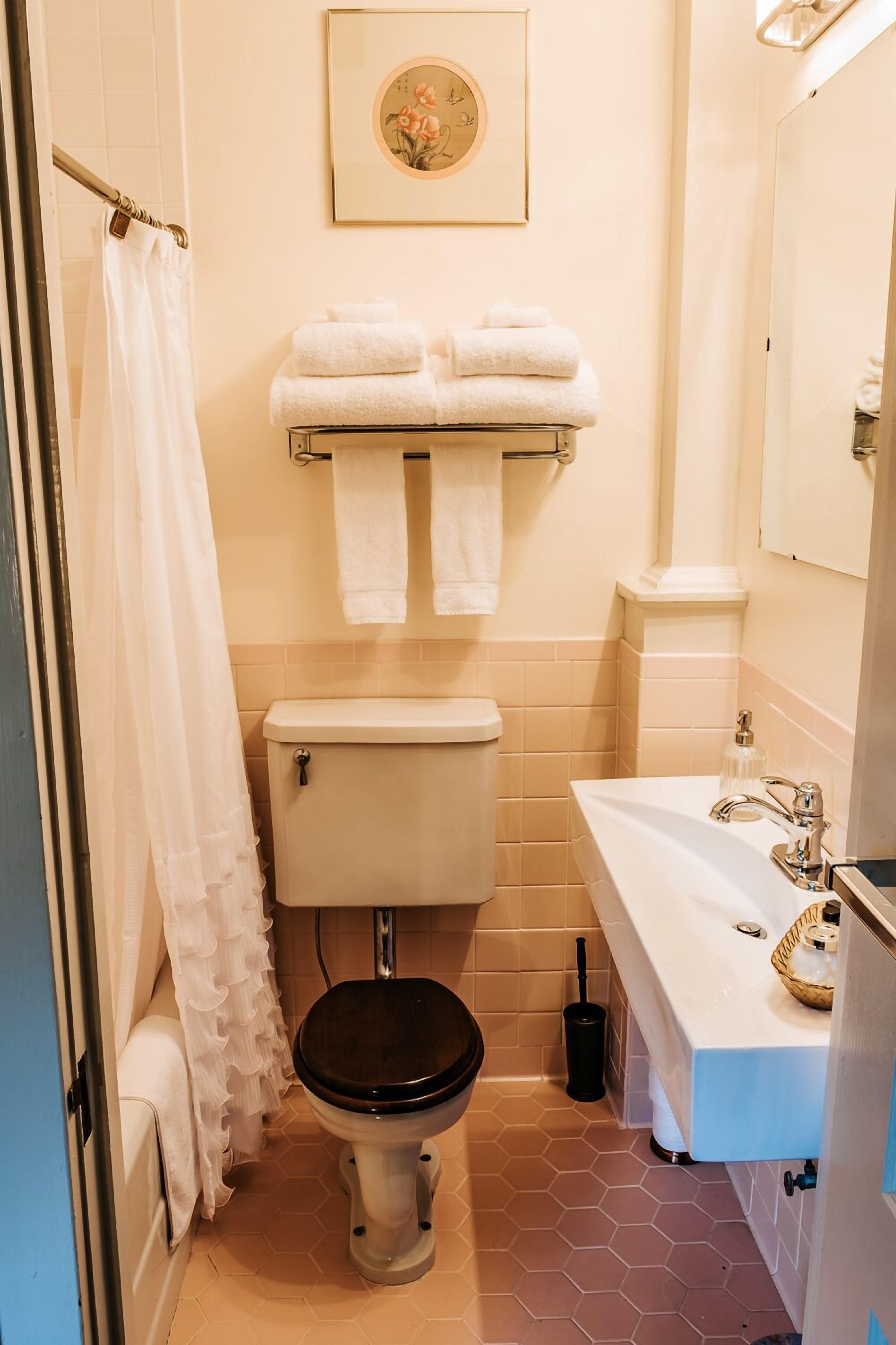 A bathroom with a toilet, a sink, and a shower curtain.