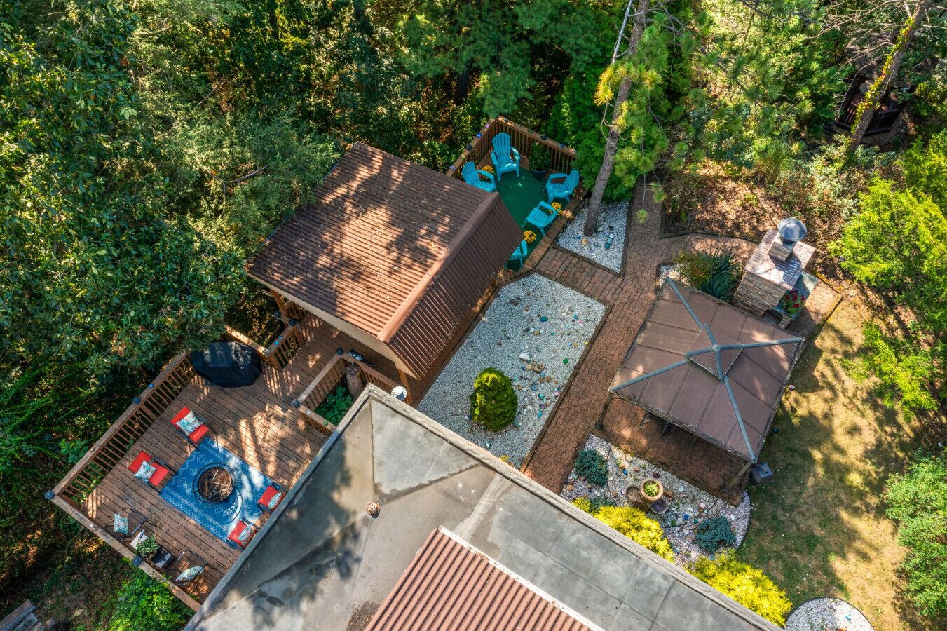 Vista aérea de una propiedad con terraza, zona de estar exterior y un pequeño jardín.