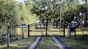 A gated entrance with a sign indicating no trespassing and the name "Coast Cottage."