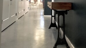 Een gang met lockers, een spiegel en een tafel.