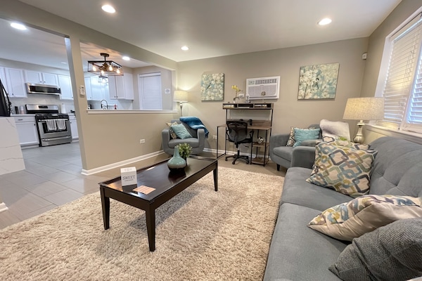 The living room is equipped with Comfy living room seating, & decorative pillows